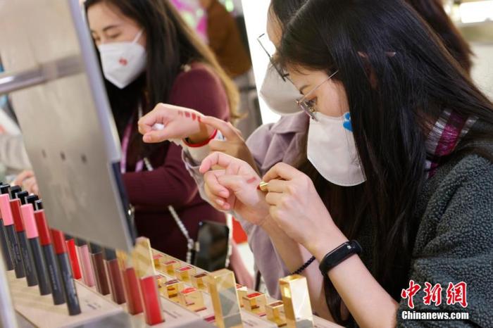 圖為女生正在體驗口紅產(chǎn)品。 殷立勤 攝