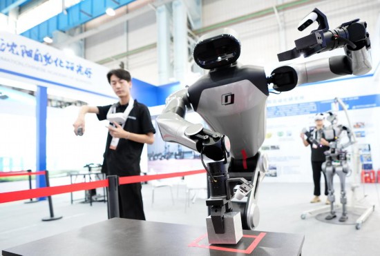 9月5日，在沈陽的2025全球工業(yè)互聯(lián)網(wǎng)大會的展覽區(qū)現(xiàn)場，中國科學(xué)院沈陽自動化研究所的機(jī)器人工程師在調(diào)試具身智能操作系統(tǒng)。新華社記者 李鋼 攝